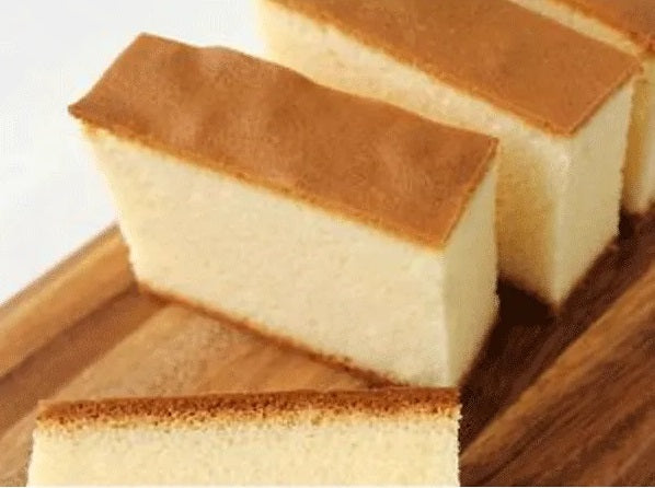 Sakura Seika Hokkaido Milk Castella 3P with moist, fine texture and gentle milk flavor on a wooden board. Contains egg, dairy, wheat, soybean.