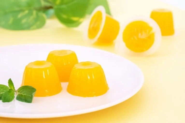 Mango flavored dietary fiber jellies on a white plate, perfect for a healthy lifestyle, providing daily fiber needs. Contains dairy.
