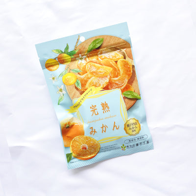 Packaging of bite-size soft dried orange slices with artistic citrus illustrations on a light background.