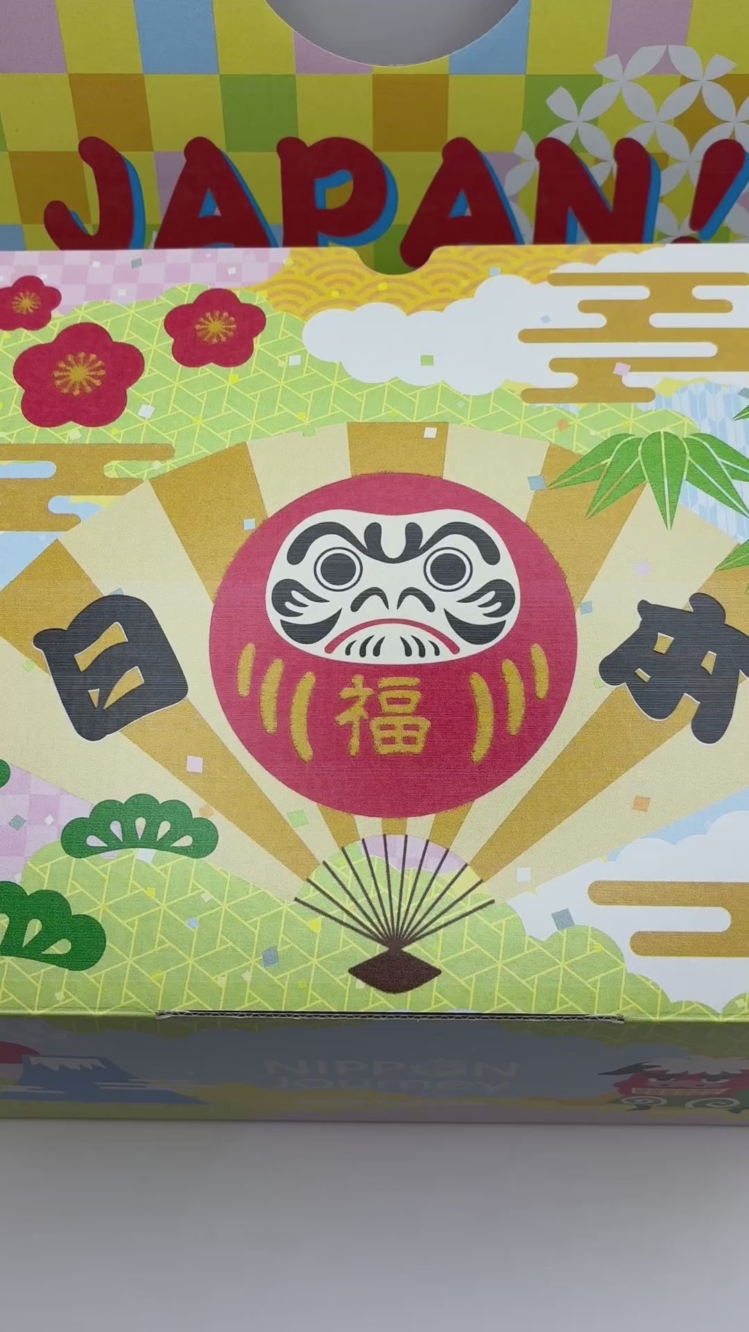 Colorful Japanese snack box with traditional Daruma doll and floral design, part of the Past Box Japanese Snack Party set by NIPPON Journey.