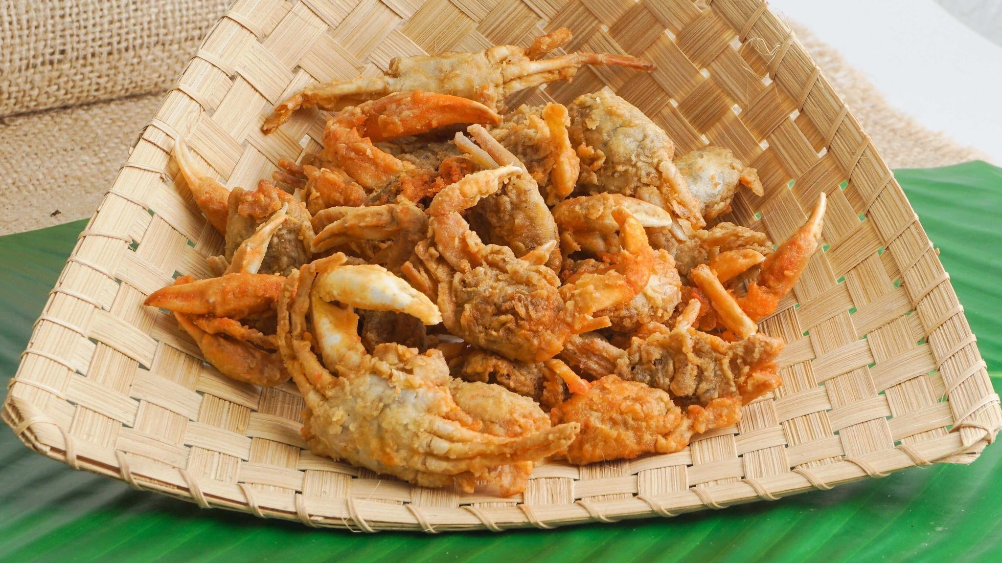 Crispy Japanese crab snacks on a woven bamboo plate from NipponJourney.